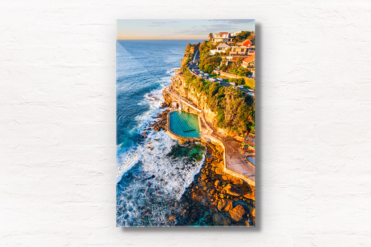 Aerial seascape of Bronte Rockpool bathed in a warm glow from the sunrise during Winter.