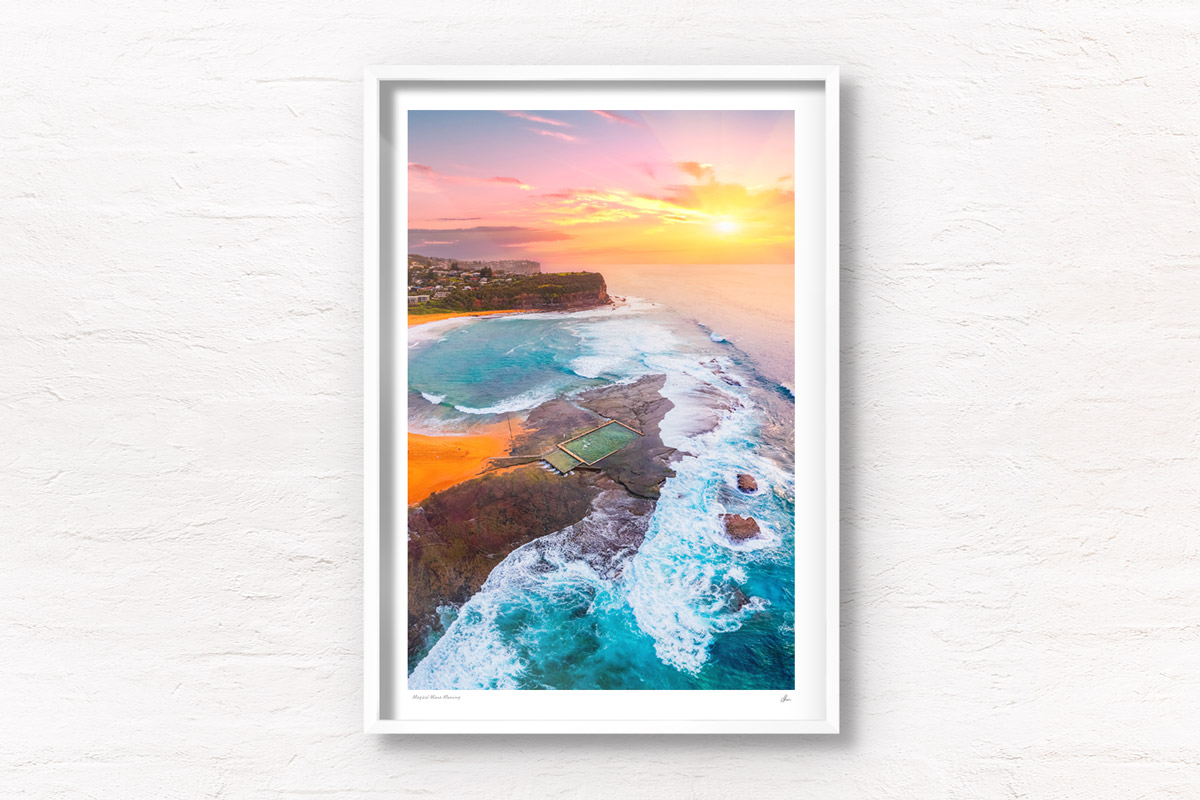 A morning sunrise peering through a cloudy sky, lighting up Mona Vale Rockpool in Sydneys Northern Beaches.