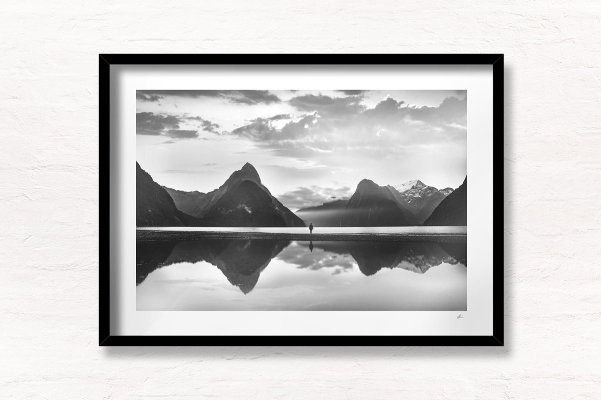 Milford Sound New Zealand. Reflection of woman and mountains at sunset.