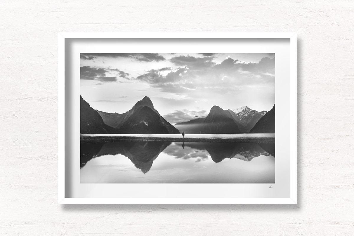 Milford Sound New Zealand. Reflection of woman and mountains at sunset.