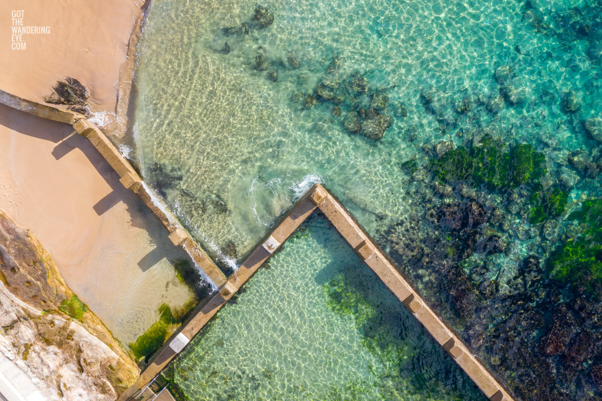 Aerial beach shot above the seaside oceanpool and turquoise waters of Ross Jones Rockpool, Coogee