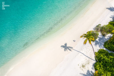 Wanderlust Maldives. Woman walking on white sands on the tropical island of the Maldives.