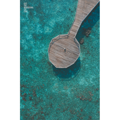 Maldives Pier Woman. Aerial above Indian Ocean.