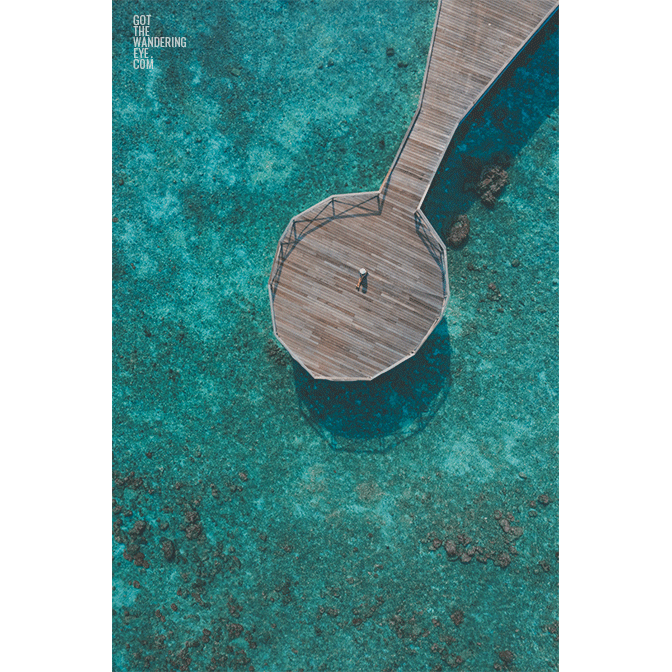 Maldives Pier Woman. Aerial above Indian Ocean.