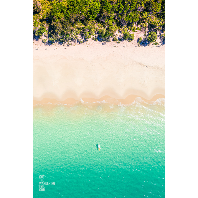 Aerial oceanscape overlooking a kayaker paddling to the beautiful South Coast's Jibbon Beach