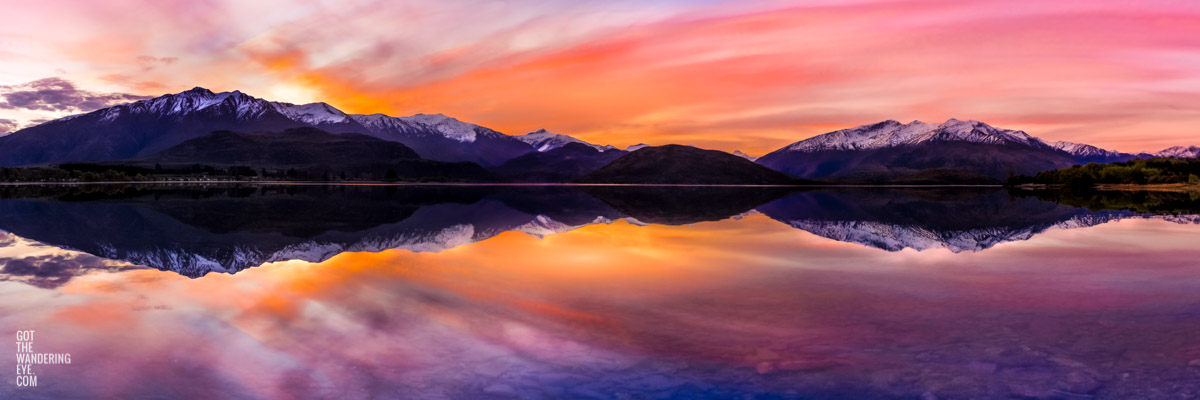 Wanaka New Zealand Sunset. Reflection of pink orange sky sunset.