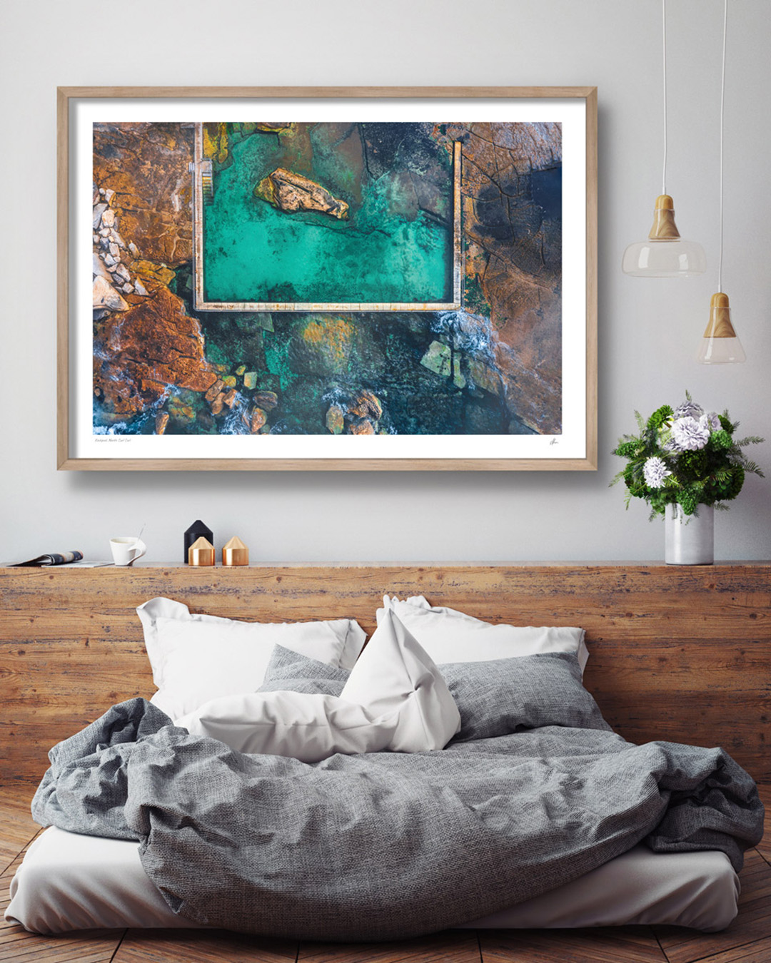Interior styling inspiration. Fine art framed print in an oak frame of iconic North Curl Curl Rockpool, Northern Beaches hanging in bedroom. 