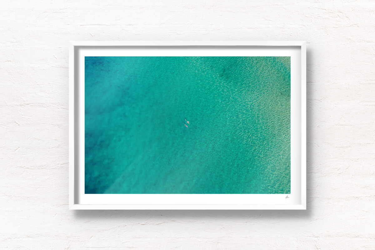 Aerial photograph of couple of swimmers swimming in the clear ocean waters of Bondi Beach, Sydney
