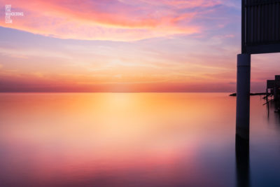 Overwater Bungalow Sunrise. Spectacular golden sunrise over silky ocean in the Maldives