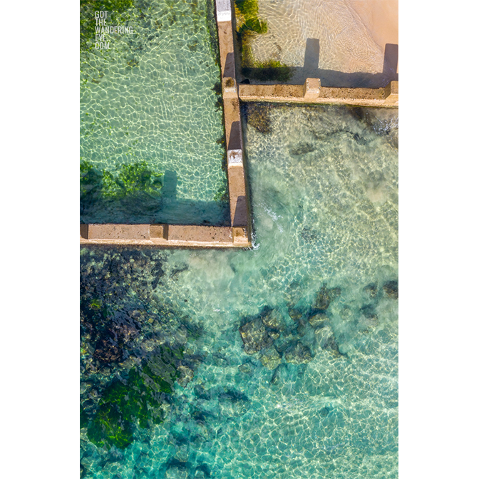 Aerial beach shot above the seaside oceanpool and turquoise waters of Ross Jones Rockpool, Coogee. Ocean Pools Sydney