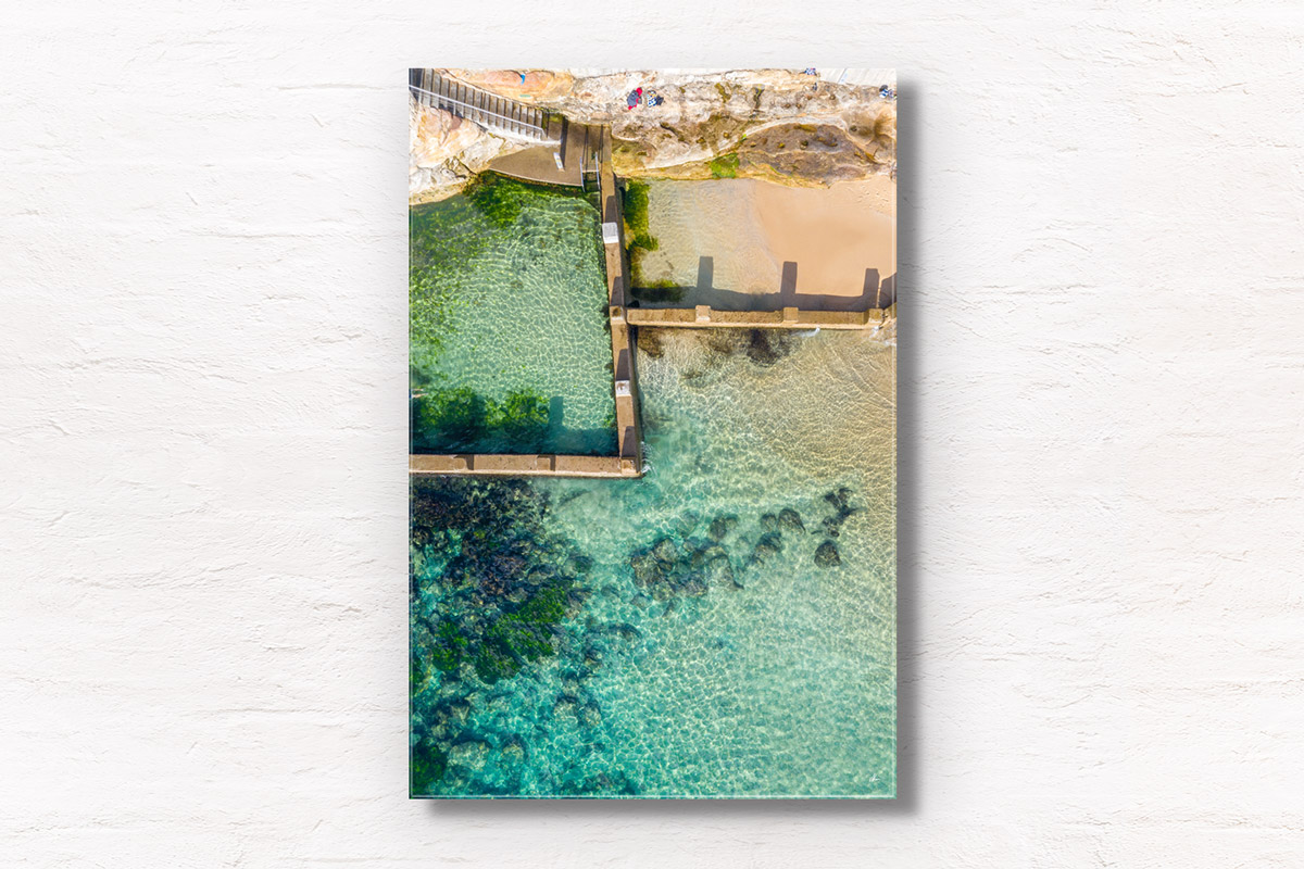 Aerial beach shot above the seaside oceanpool and turquoise waters of Ross Jones Rockpool, Coogee