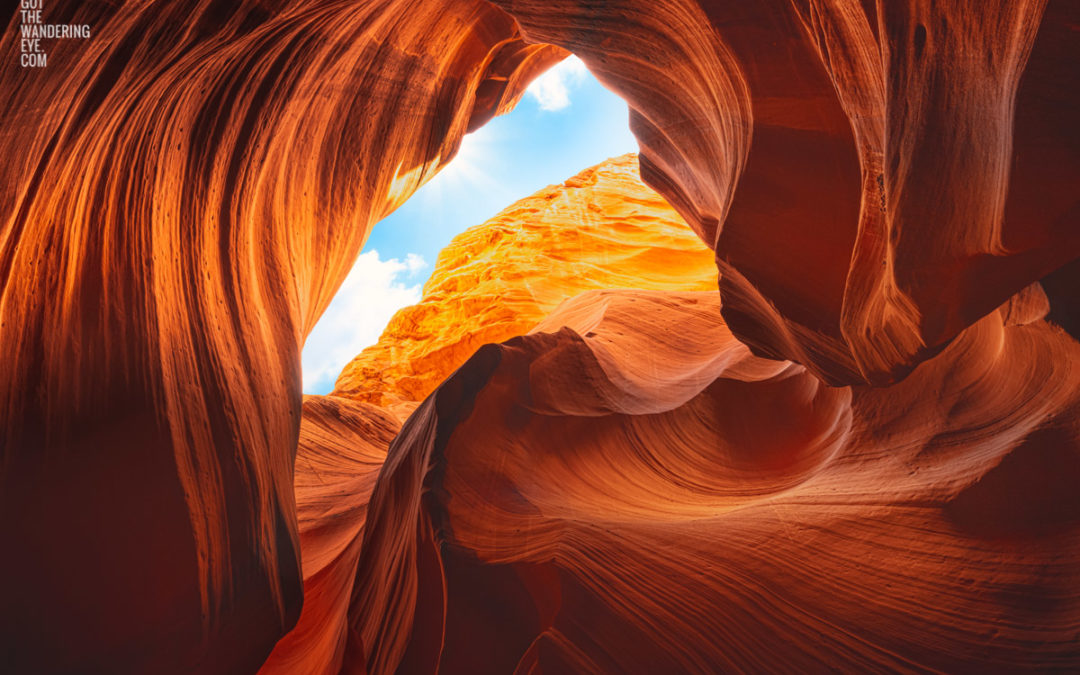 Looking up to the sky through the swirling sandstone textures of the slot canyon at upper Antelope Canyon, Arizona.