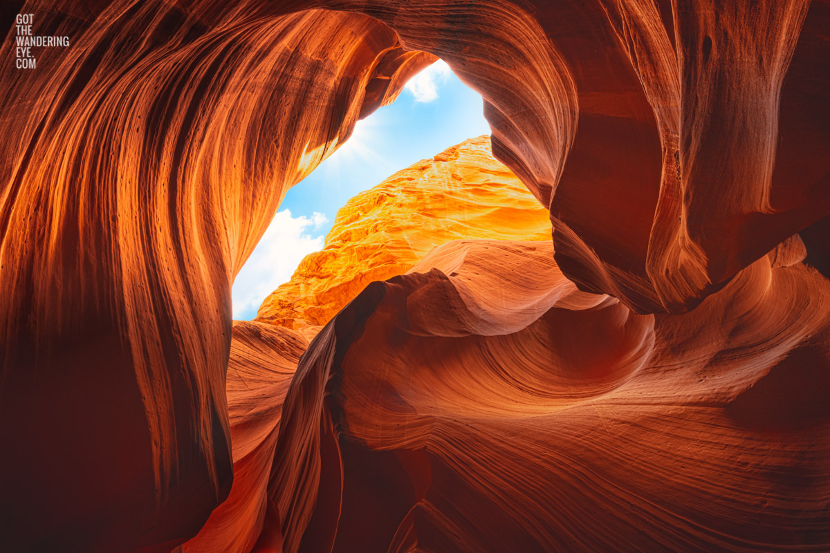 Looking up to the sky through the swirling sandstone textures of the slot canyon at upper Antelope Canyon, Arizona.