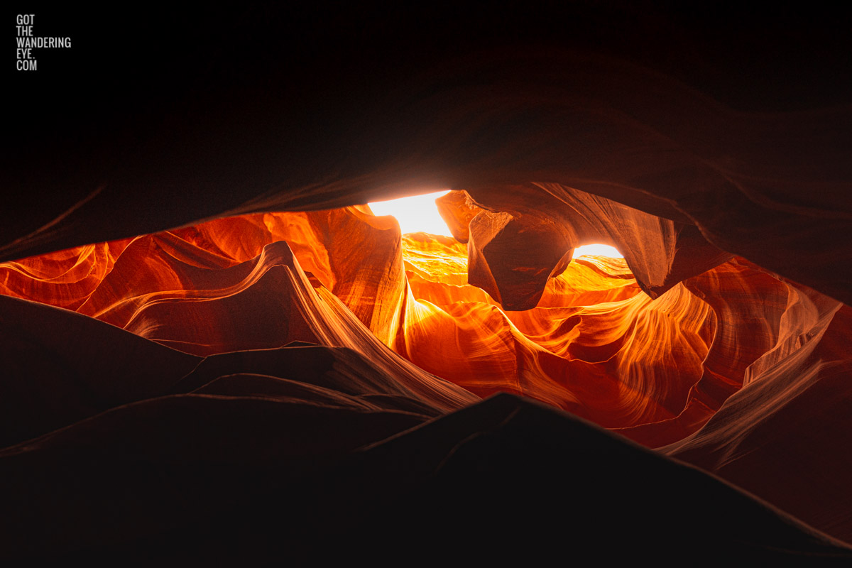 Looking up to the sky through the Dragons Eye and swirling sandstone textures of the slot canyon at upper Antelope Canyon, Arizona.