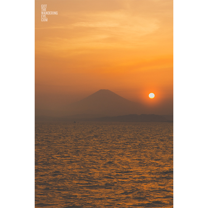 Gorgeous sunset, dropping down into the ocean over the silhouette of Mount Fuji, Japan