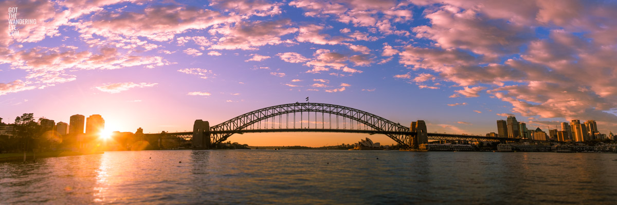 Panoramic view of a stunning sunrise and pink sky behind the Sydney Harbour Bridge Silhouette