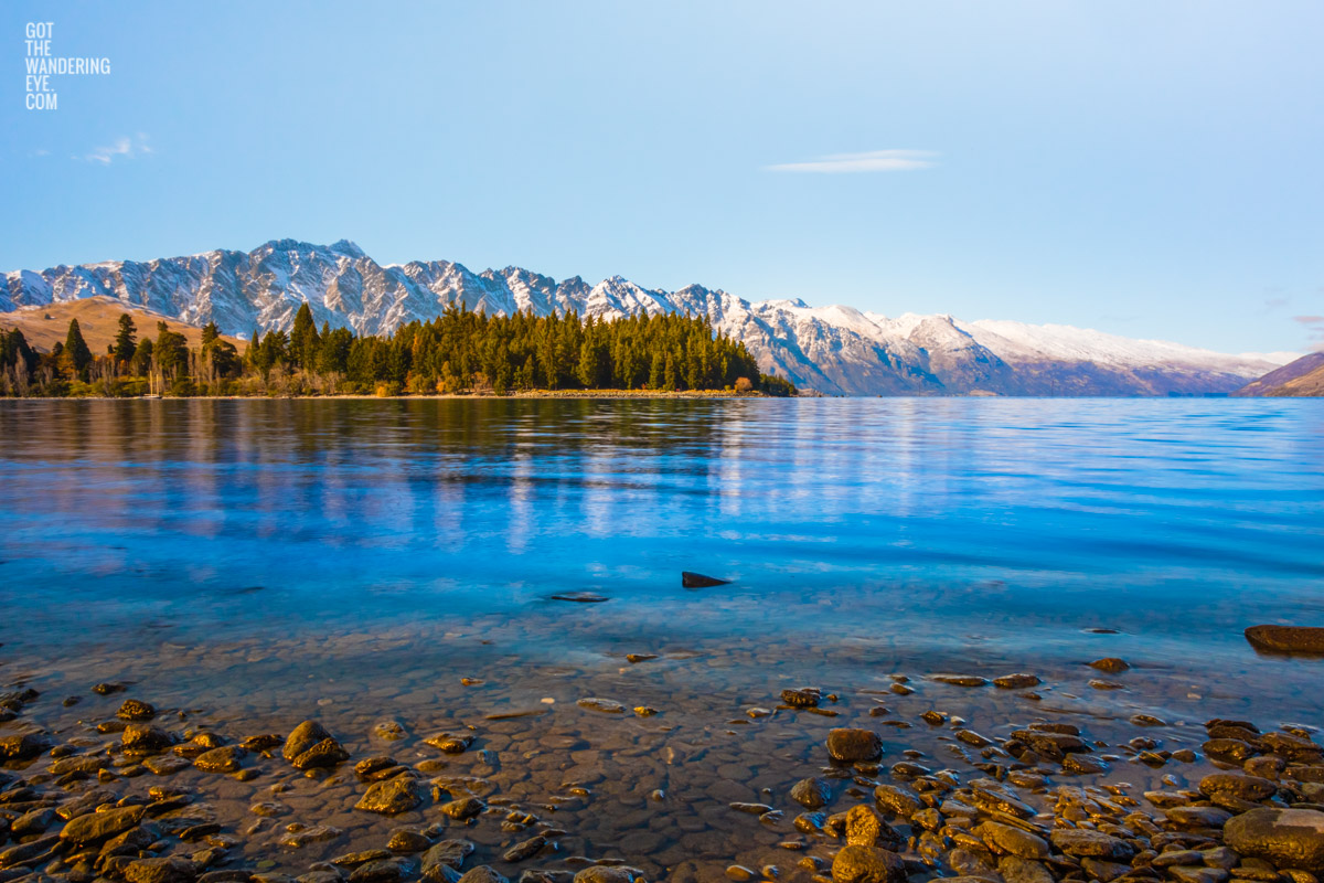 Lakeside at Lake Wakitipu, looking out towards snowcapped mountains, Queenstown, New Zealand.