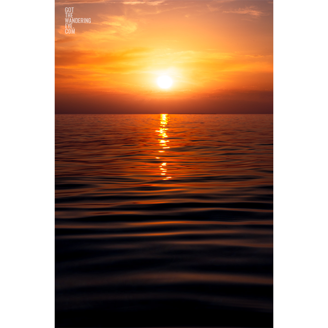 Fiery morning sunrise rising over the waters of the Maldives. Hot Summer Sunrise