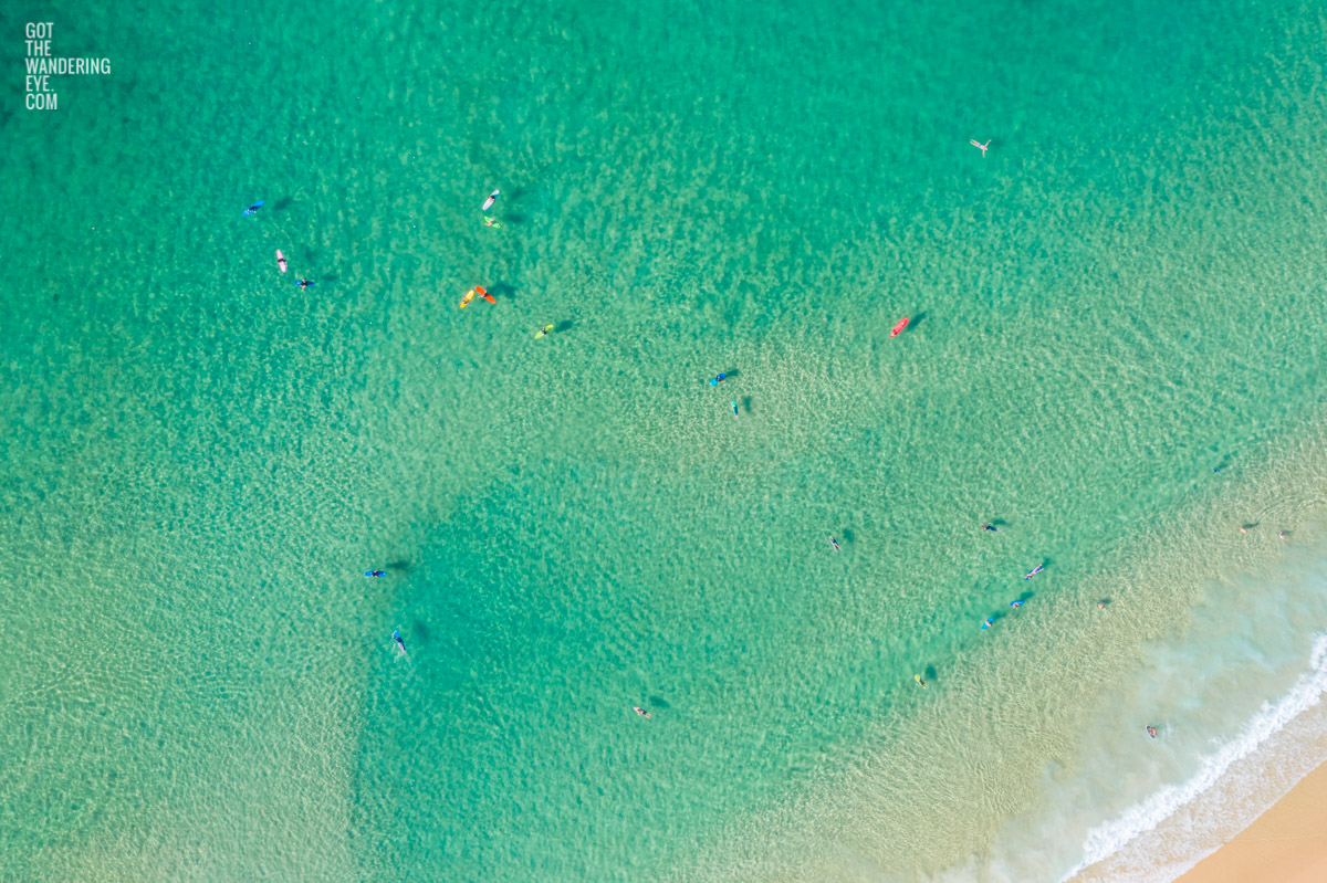 Aerial oceanscape above crystal clear waters on Bondi beach with colourful surfboards