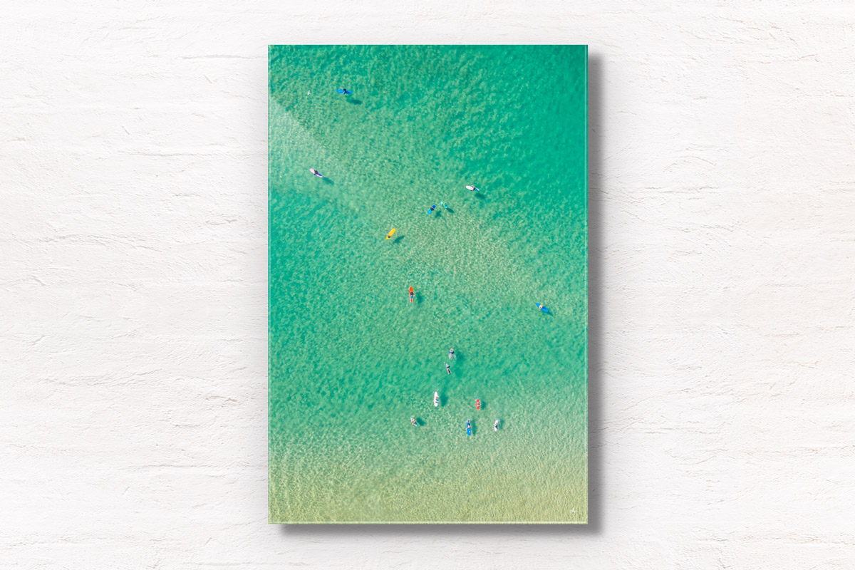 Aerial oceanscape above crystal clear waters on Bondi beach with colourful surfboards