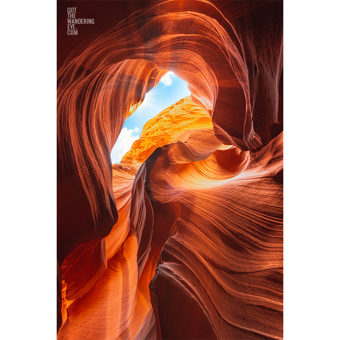 Looking up to the sky through the swirling sandstone textures of the slot canyon at upper Antelope Canyon, Arizona.