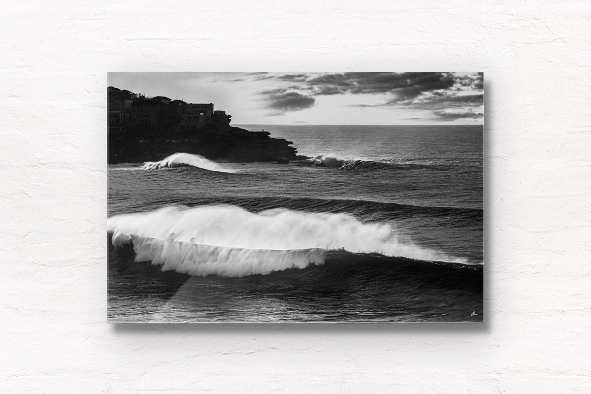 Black and white photo of huge waves crashing over Bondi Beach