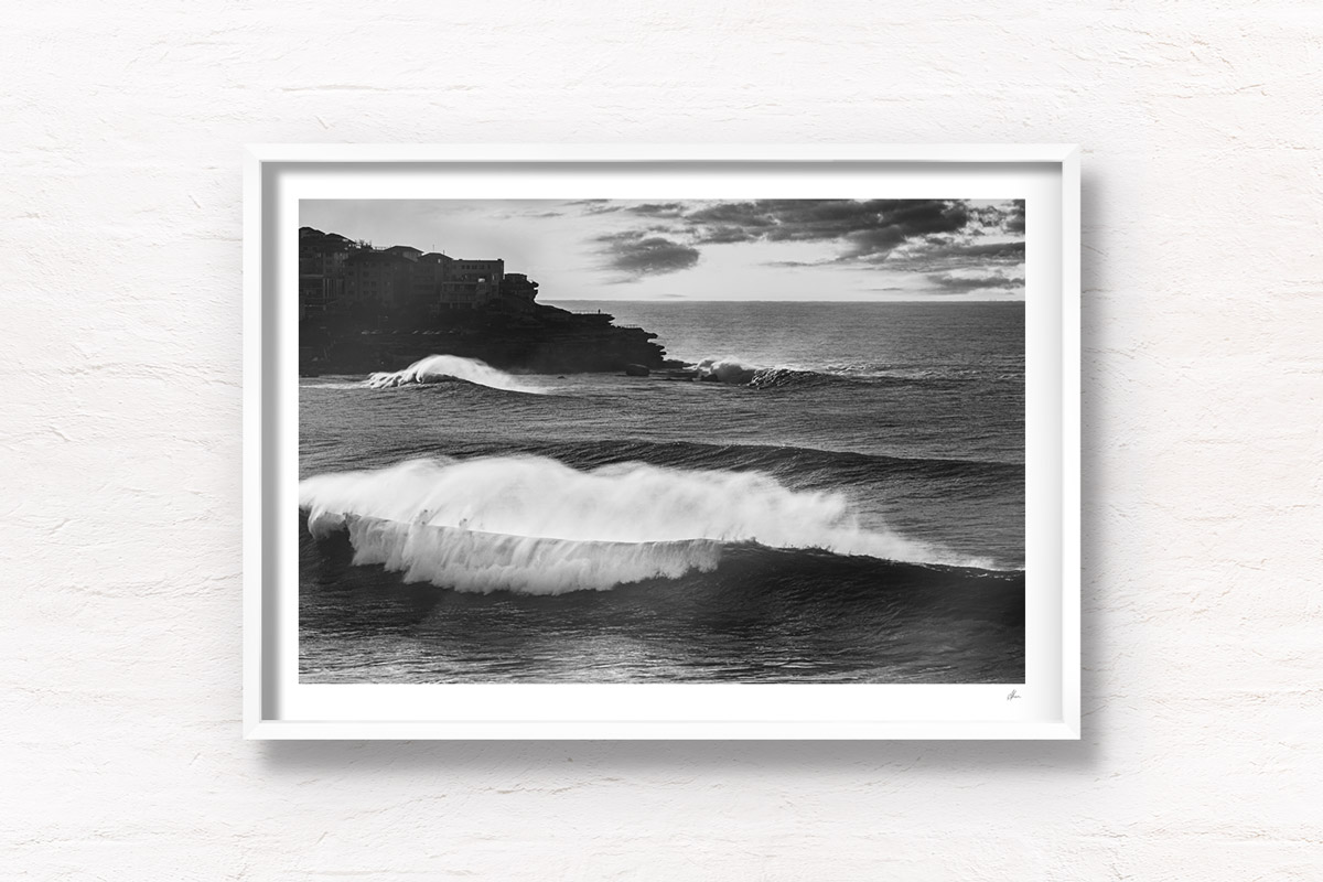 Black and white photo of huge waves crashing over Bondi Beach