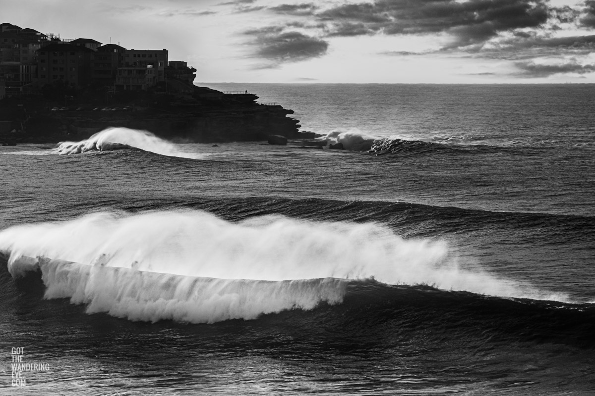 Black and white photo of huge waves crashing over Bondi Beach