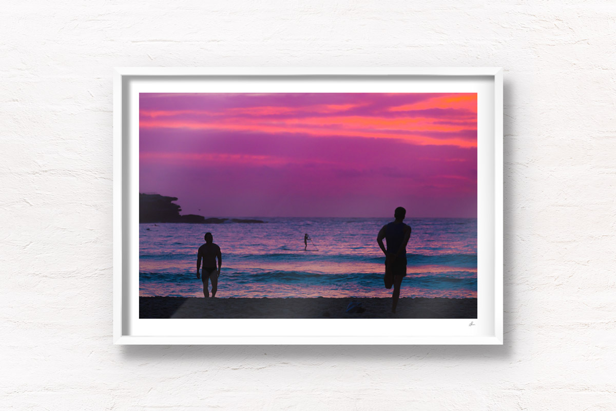 Silhouettes of people enjoy a spectacular pink sky sunrise looking towards Ben Buckler, Bondi Beach