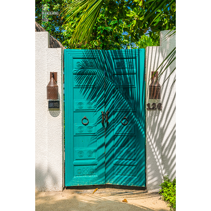 Tropical vibes with a palm tree shadow on gorgeous Maldivian Beach Villa Door. Maldives Beach House