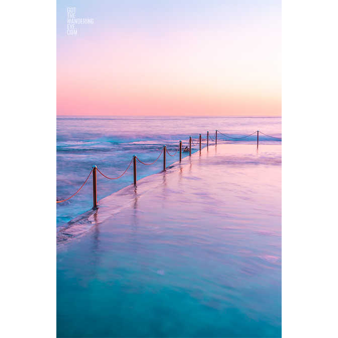 Sydney Ocean Pool Sunrise. Long exposure of pastel coloured sunrise over Wylie's Baths, ocean pool in Coogee.