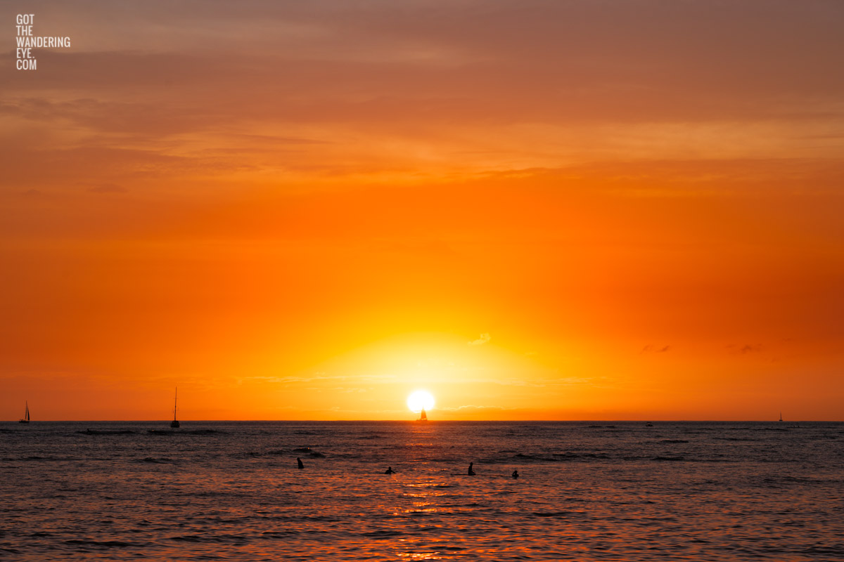 Stunning sun setting into the ocean at Waikiki Beach, Hawaii. Sail into Sunset