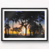 Sunset and silhouette of palm trees and woman walking along Waikiki Beach, Hawaii