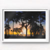 Sunset and silhouette of palm trees and woman walking along Waikiki Beach, Hawaii