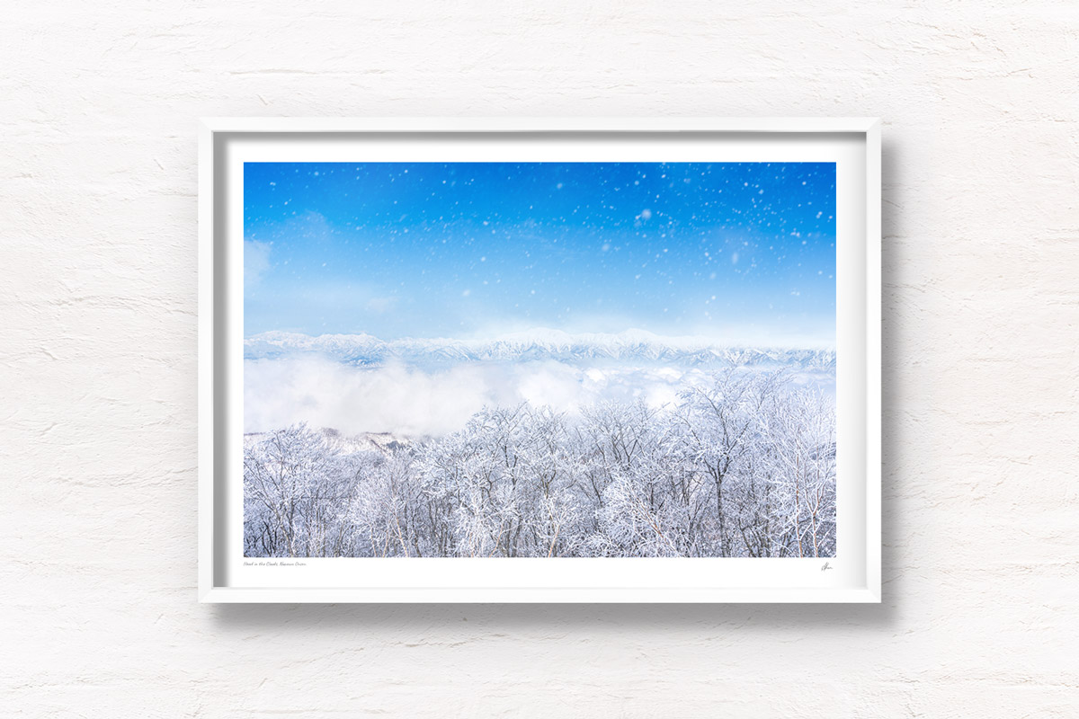 Mountains appearing above a sea of clouds and snowy trees in Nozawa Onsen, Japan