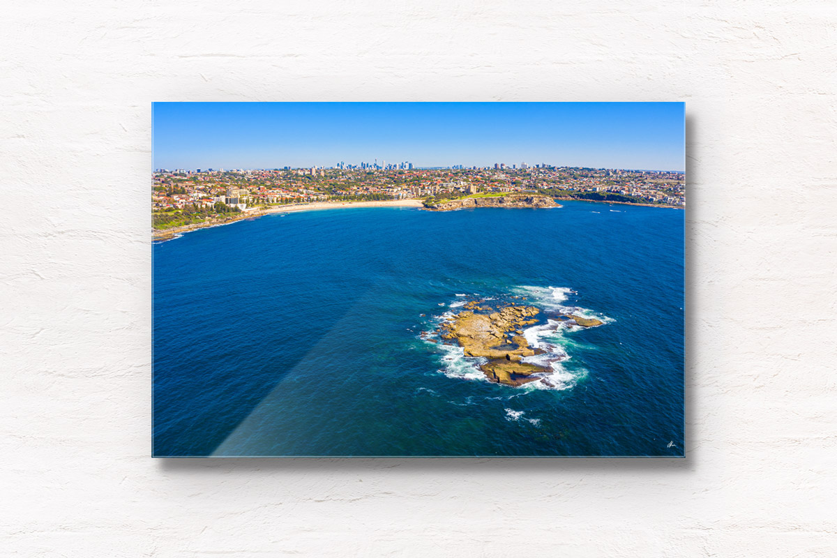 Aerial seascape above Wedding Cake Island looking back to Coogee Beach and the Sydney skyline