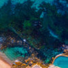 Aerial seascape above the blue waters of Bronte Beach Rockpool.