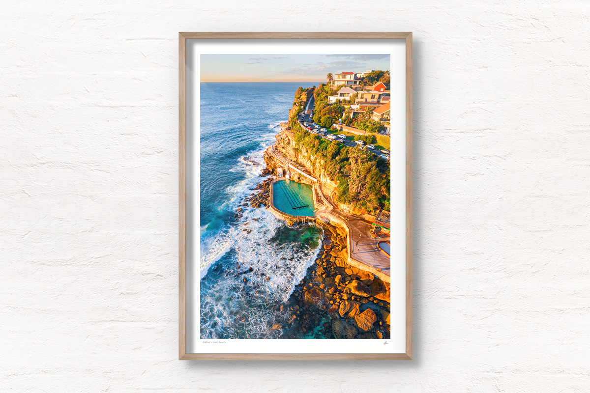 Aerial seascape of Bronte Rockpool bathed in a warm glow from the sunrise during Winter.