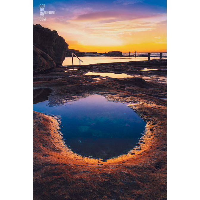 Fiery purple sky sunrise in a puddle of water at Mahon Pool, Maroubra