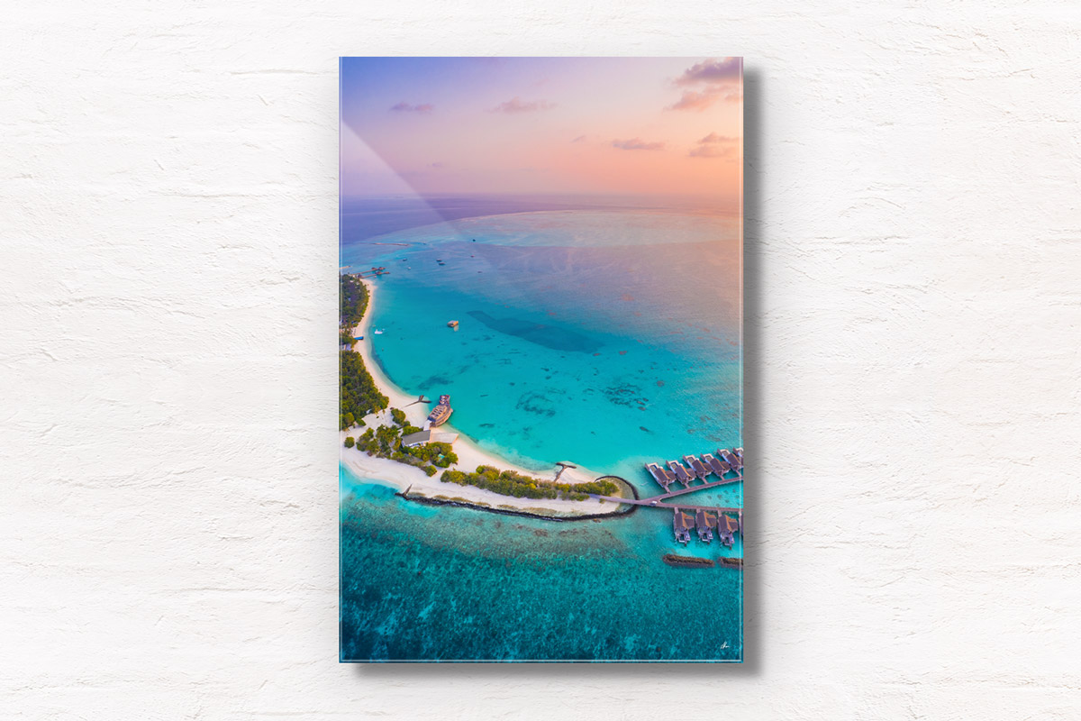 Aerial seascape above a beautiful sunset above the tiny paradise island of Fairmont Maldives.