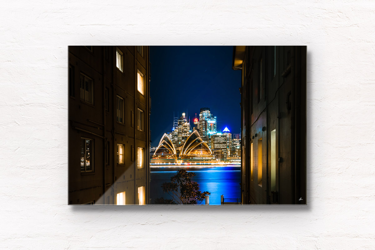 Long exposure photography of ferries going past the sparkling Sydney Opera House on a clear winters night in Sydney overlooking Beulah St wharf.