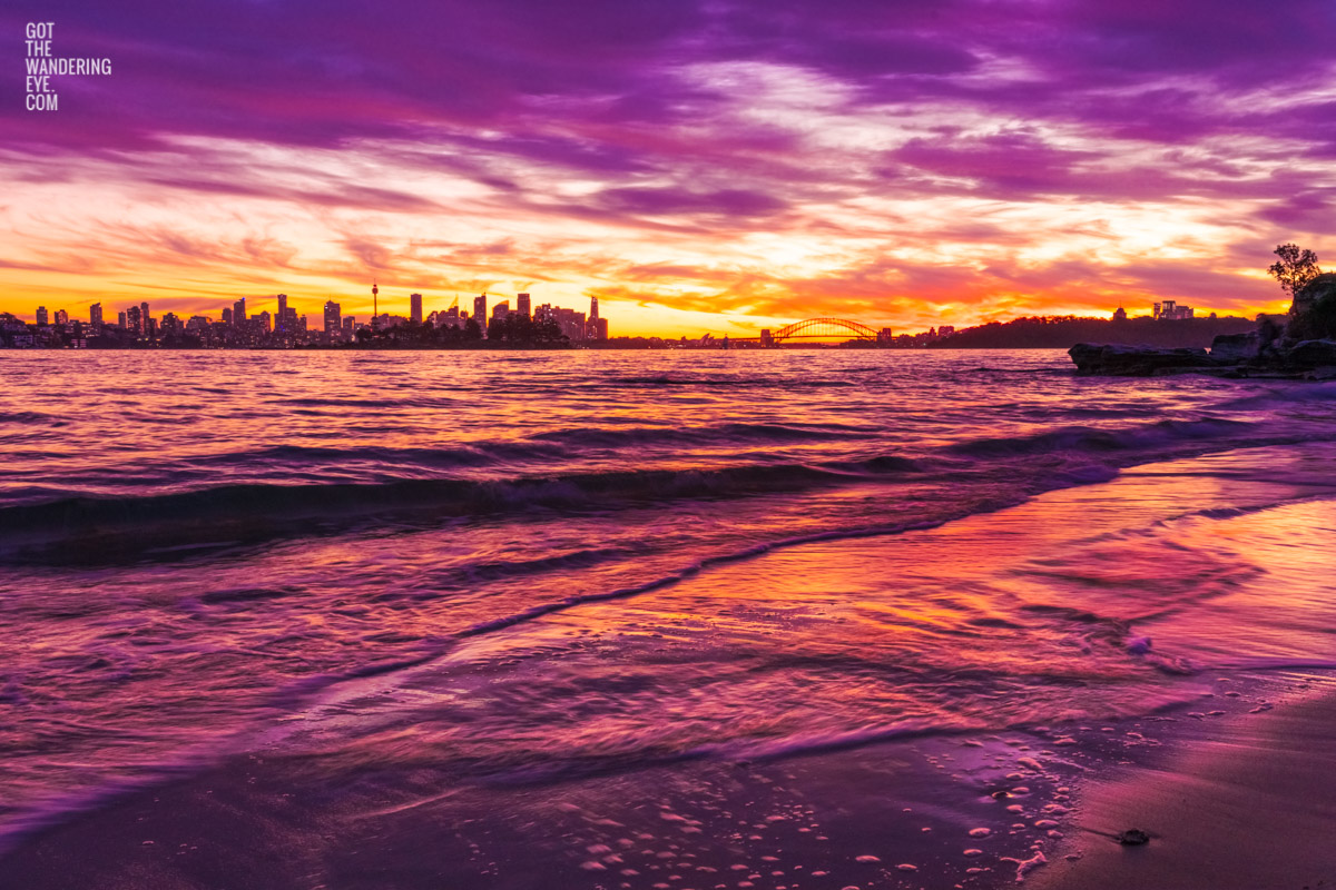 Long exposure of a gorgeous pink sky sunset, creating a silhouette over the Sydney skyline, taken from Milk Beach Vaucluse.