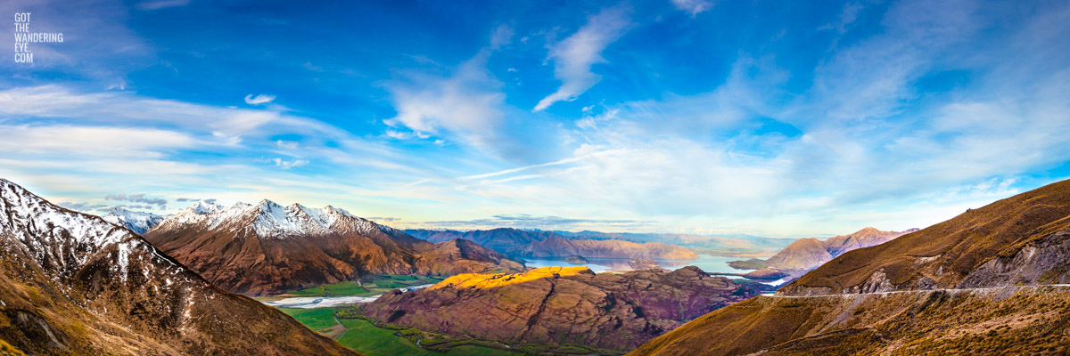 The most spectacular panoramic view down from the top of Treble Cone Road over Rocky Mountains to Lake Wanaka, New Zealand