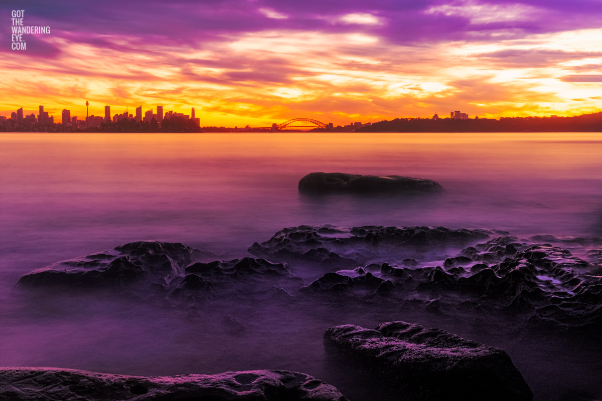 Long exposure of a gorgeous pink sky sunset, creating a silhouette over the Sydney skyline, taken from Milk Beach Vaucluse.