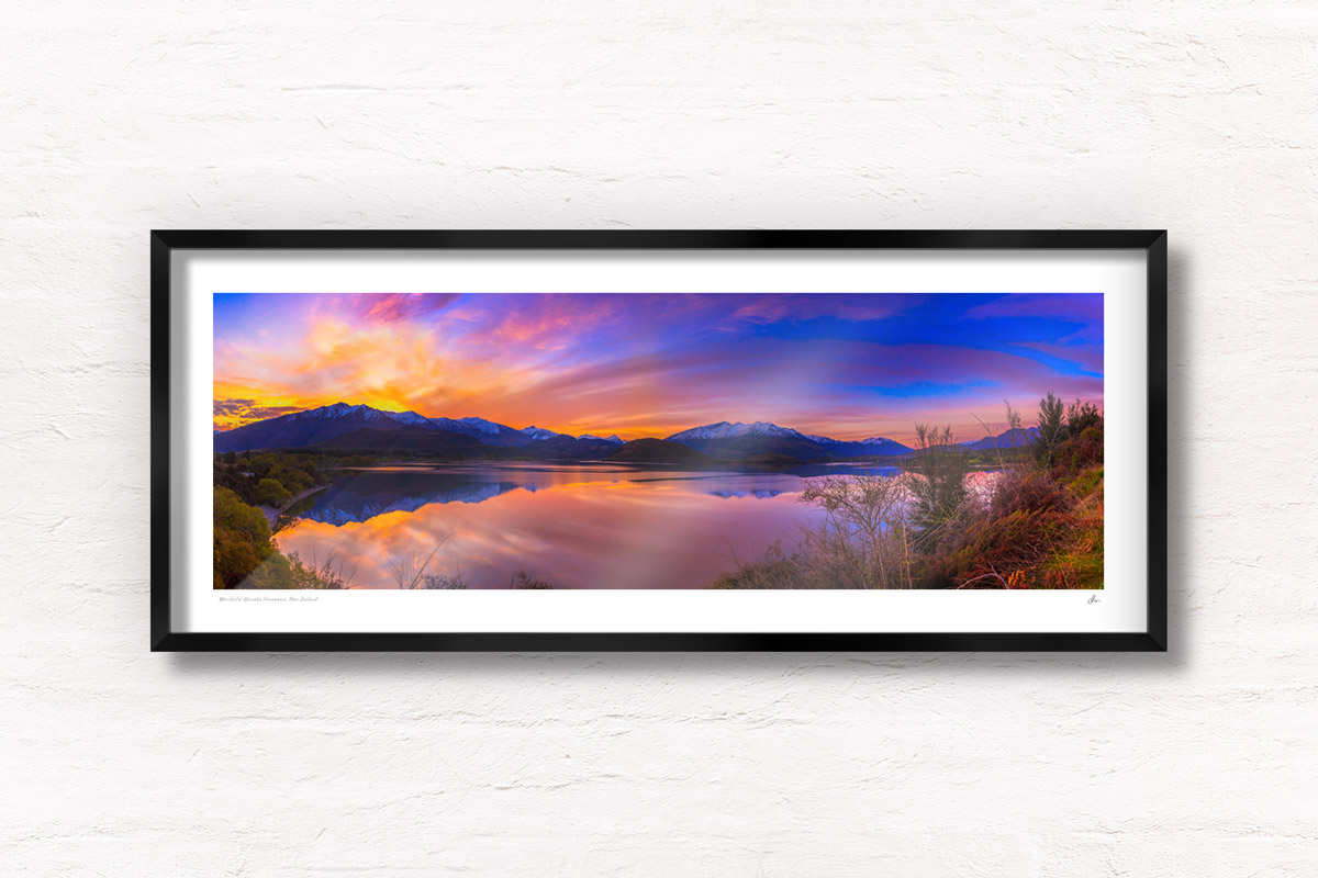 Stunning panoramic silky pink sunset sky with reflection of mountains of Wanaka New Zealand