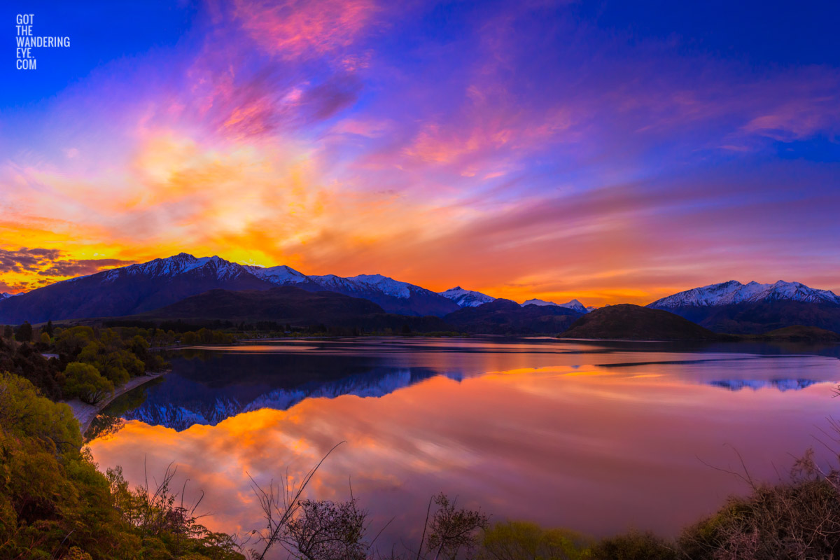 Stunning silky pink sunset sky with reflection of mountains of Wanaka New Zealand