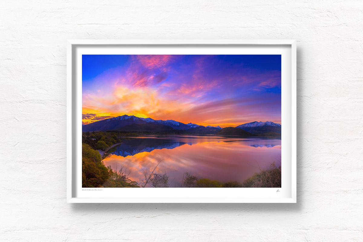 Stunning silky pink sunset sky with reflection of mountains of Wanaka New Zealand