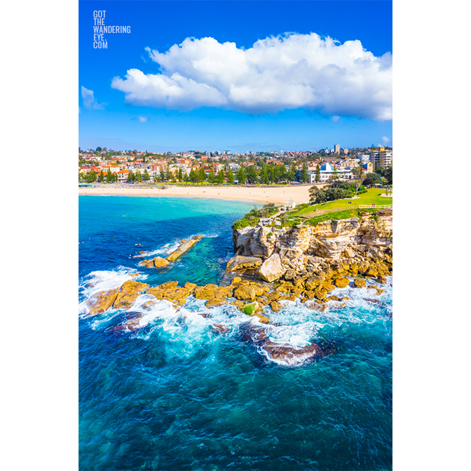 Aerial oceanscape view of Giles Baths, Bogey Hole rockpool, ocean bath from the northern headland of Coogee Beach, with the Coogee Pavilion and Coogee Beach