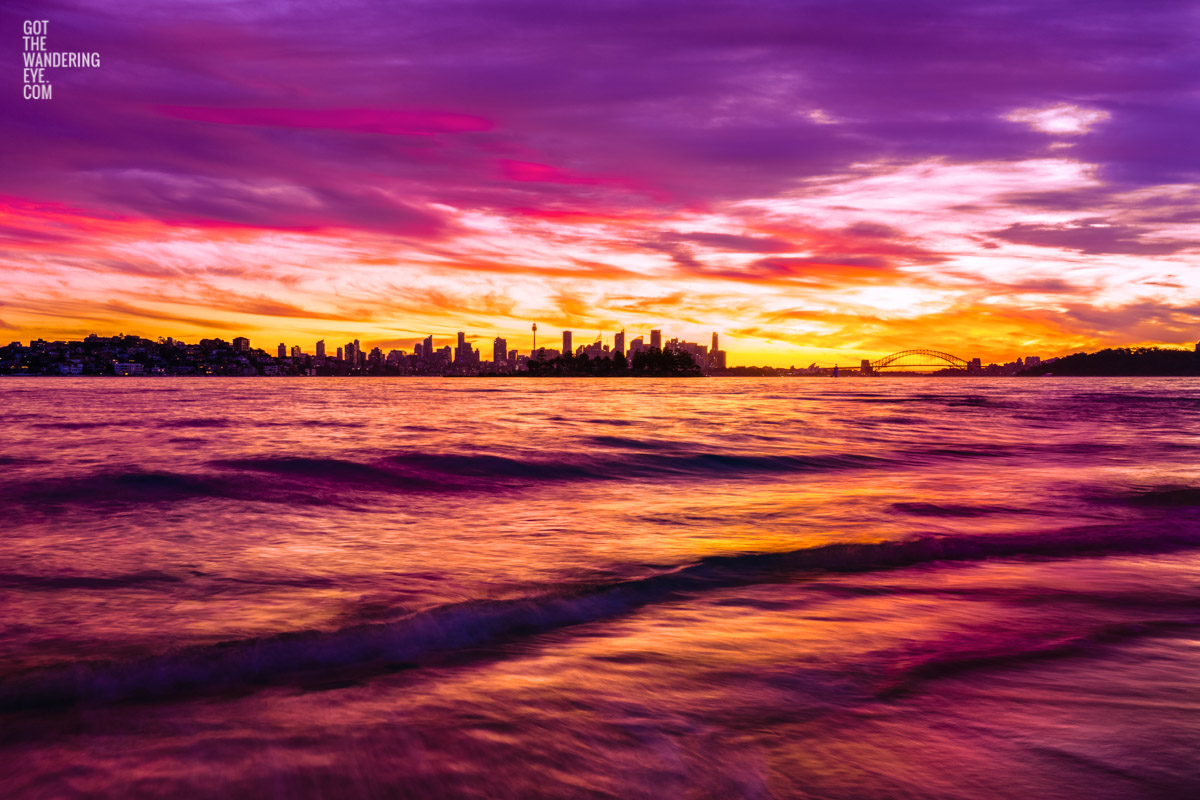 Long exposure of a gorgeous pink sky sunset, creating a silhouette over the Sydney skyline, taken from Milk Beach Vaucluse.