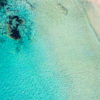 Aerial oceanscape above secluded crystal clear ocean beach waters of South Cronulla Beach